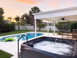 A backyard with a swimming pool and a hot tub. - Coastal Gem: Pool, Hot Tub, King Bed, & More (Port St. Lucie)