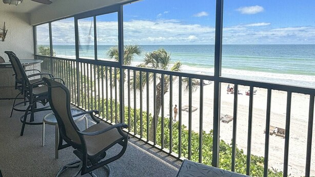 A balcony with a view of the beach and ocean. - Corner Beachfront. Large Balcony. Pool. Hot Tub. Exceptional Location. (Madeira Beach)