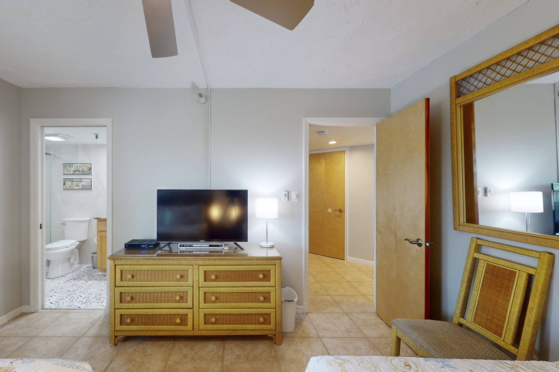 Ein Hotelzimmer mit Fernseher, Schminktisch und einem großen Spiegel.