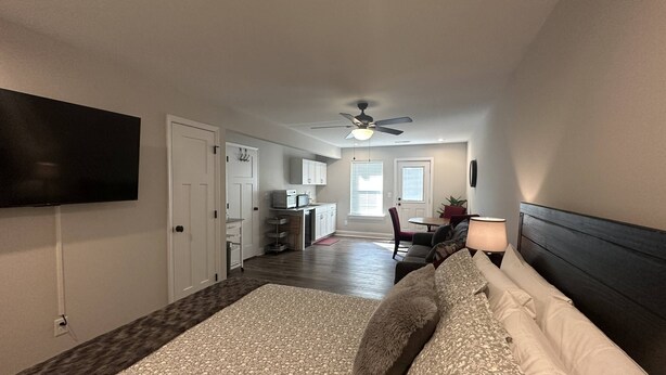 A bedroom with a bed, a TV mounted on the wall, a ceiling fan, and a view into the adjacent kitchen area. - Mid-term rental available - close to all attractions in the Greater Chattanooga and NW Georgia area (Chattanooga)