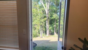 A view through a glass door into a yard with trees and a chair. - Mid-term rental available - close to all attractions in the Greater Chattanooga and NW Georgia area (Chattanooga)