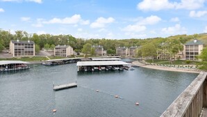 Een jachthaven met aangemeerde boten, een houten steiger en gebouwen met grote ramen.