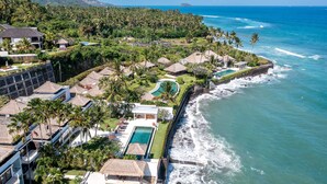 A resort with multiple bungalow-style buildings, a swimming pool, and a view of the ocean. - Villa Dahlia Manggis - 4 bed Oceanfront Retreat, with Chef & Butler Candidasa (Manggis, Karangasem)