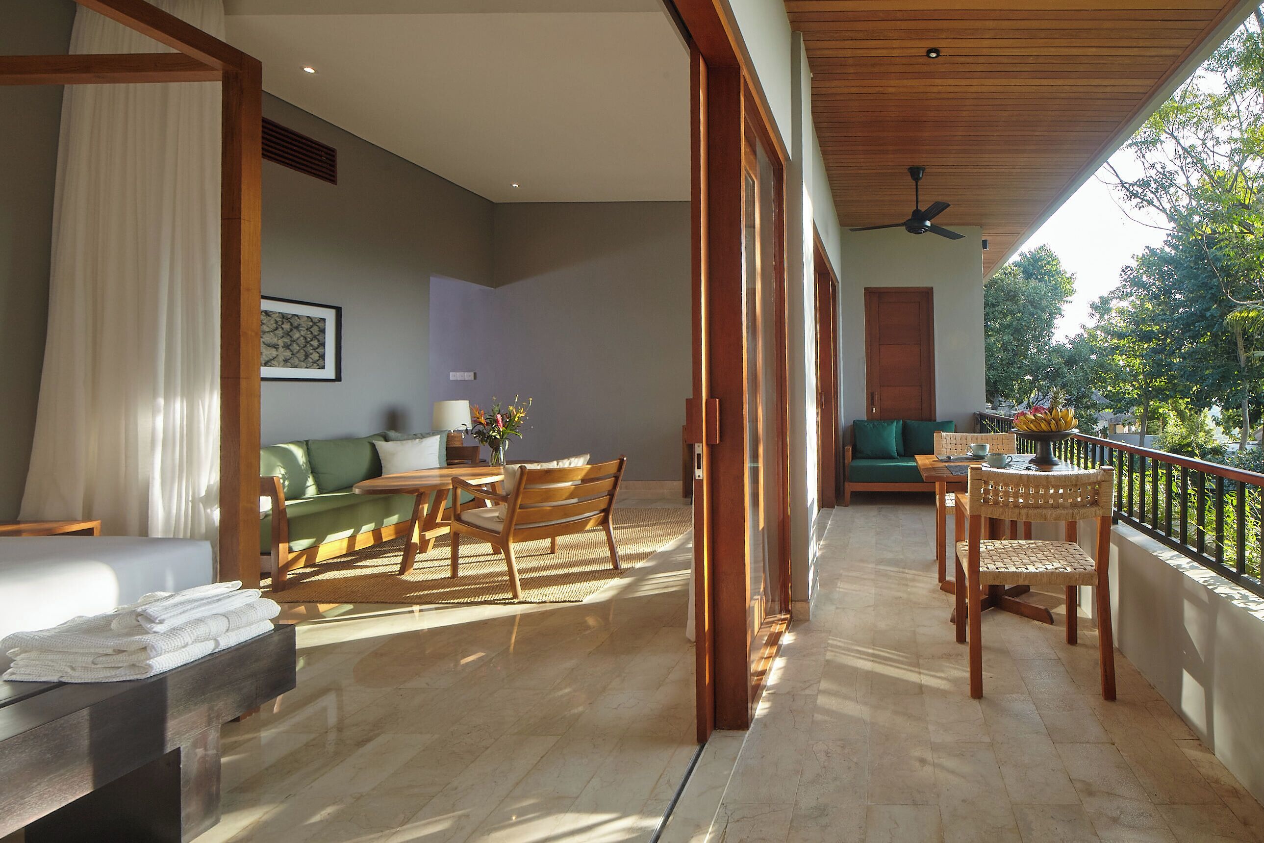 A spacious room with a balcony, a dining area, and a seating area with a sofa and chairs.