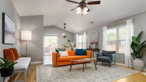A living room with a sofa, armchair, coffee table, and a ceiling fan. - Beach Time! w/ King Beds, Pool, Fire Pit, & Tennis (Wilmington)