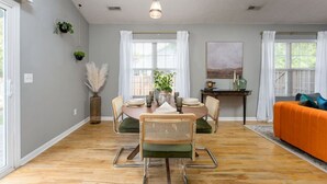 A dining area with a round table, chairs, and a hanging light fixture. - Beach Time! w/ King Beds, Pool, Fire Pit, & Tennis (Wilmington)