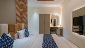 Una camera d'albergo moderna con un letto, una scrivania, una sedia, una TV e uno specchio.