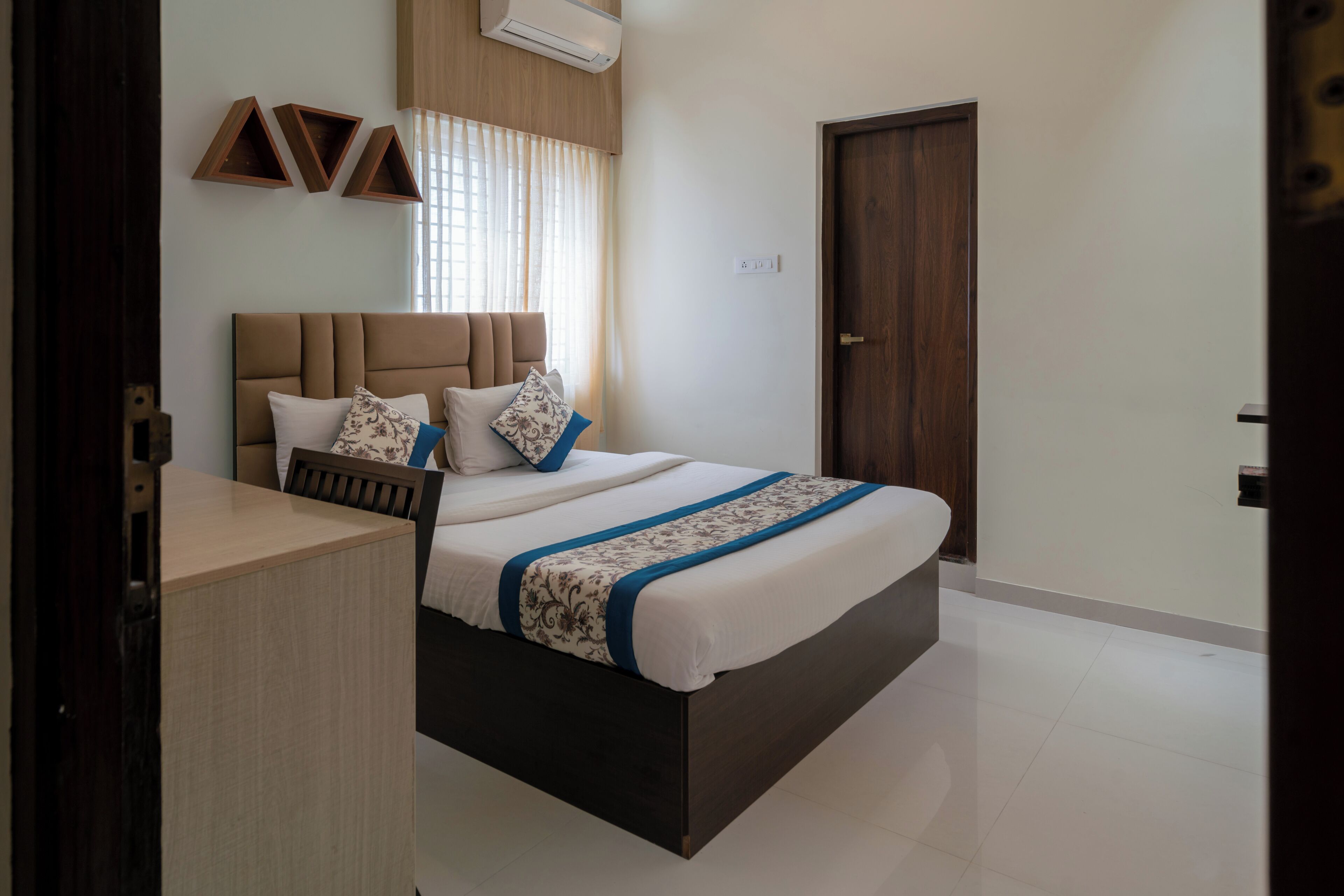A bedroom with a bed, bedside table, and a door.