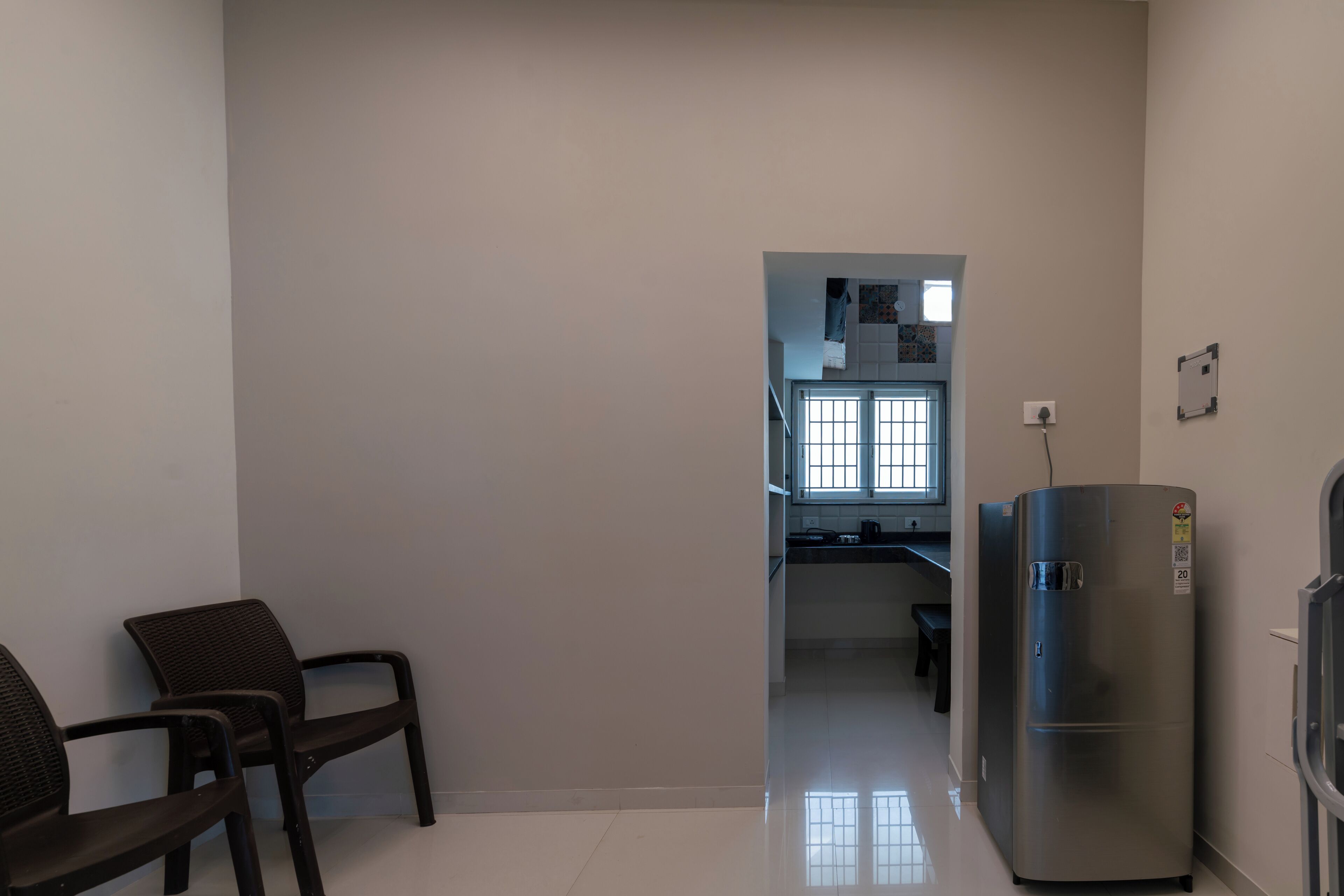Un pasillo con una zona de cocina al fondo, que incluye un refrigerador y una ventana.