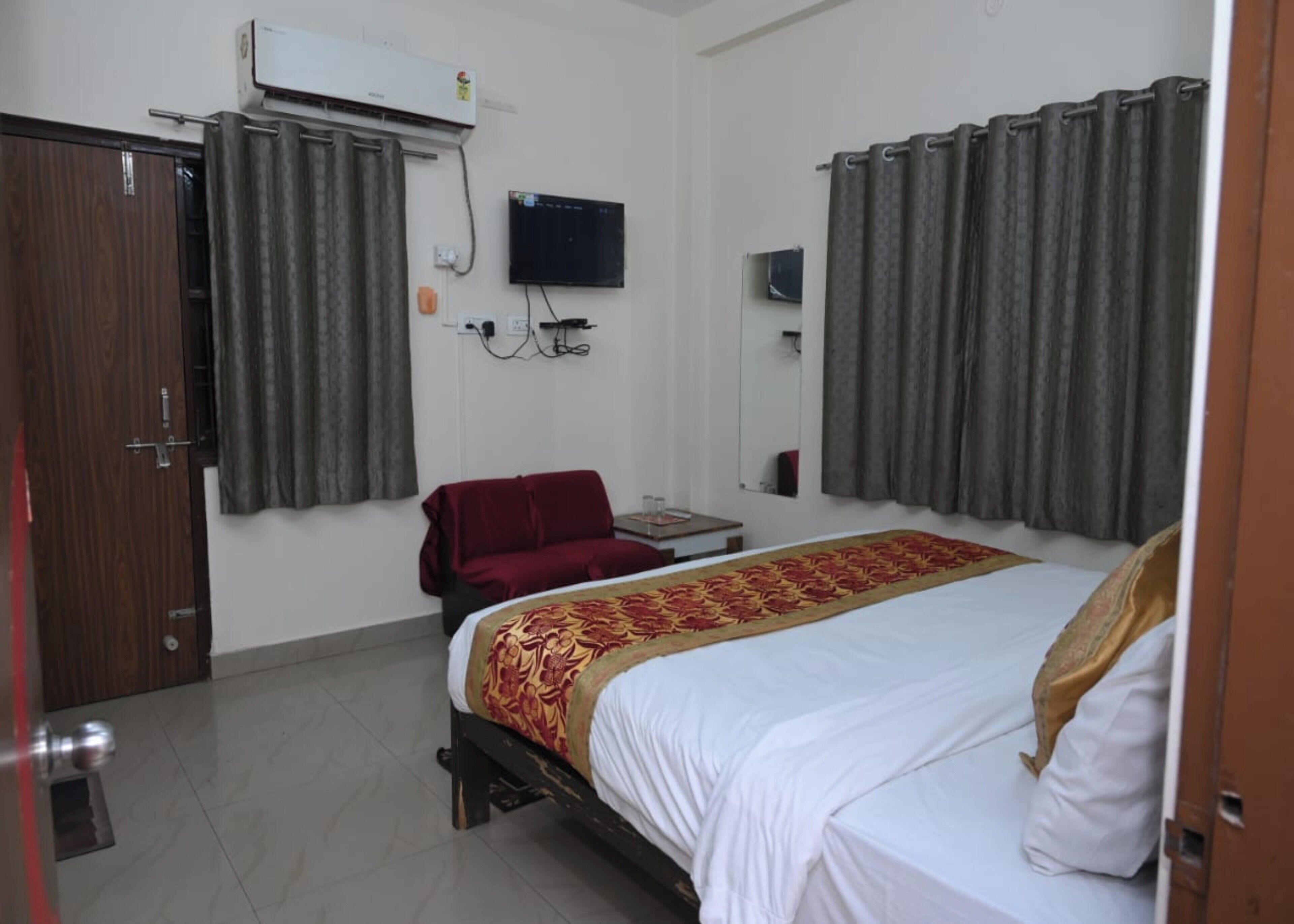 Una habitación de hotel con cama, televisión, escritorio y silla.
