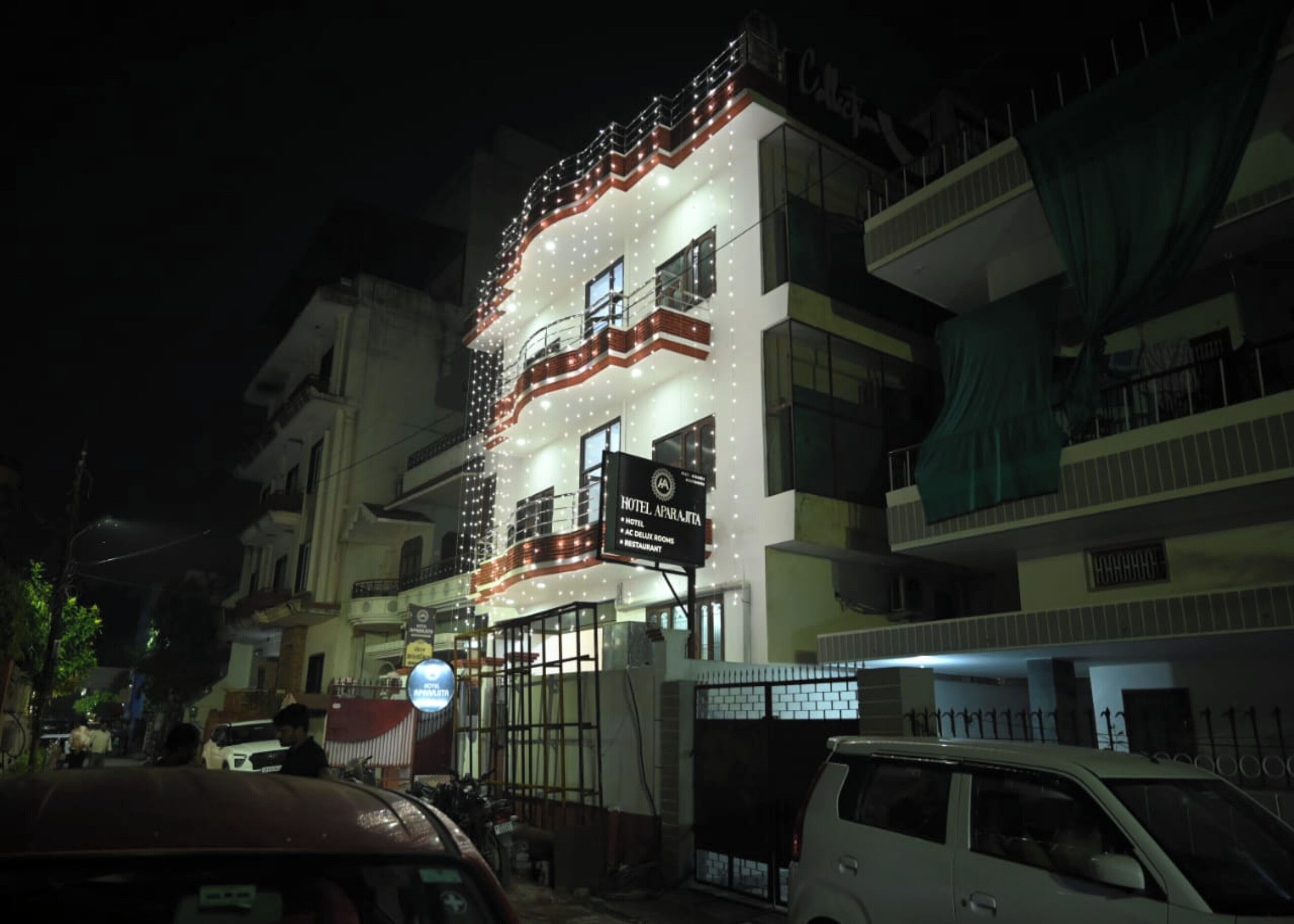 A hotel with multiple floors, balconies, and a sign indicating it offers rooms, a restaurant, and a spa.