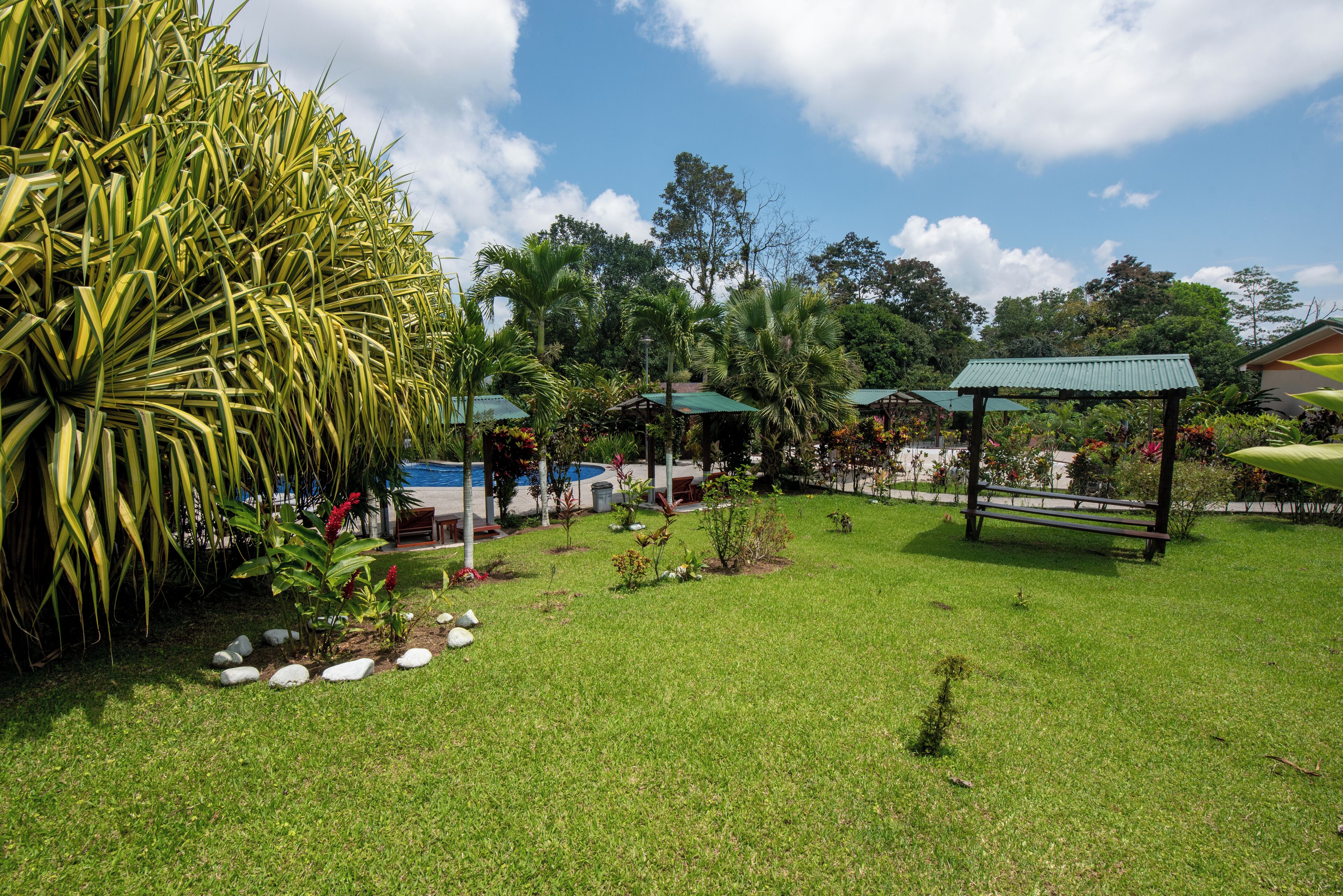 A well-maintained garden with a gazebo, seating areas, and a pool.