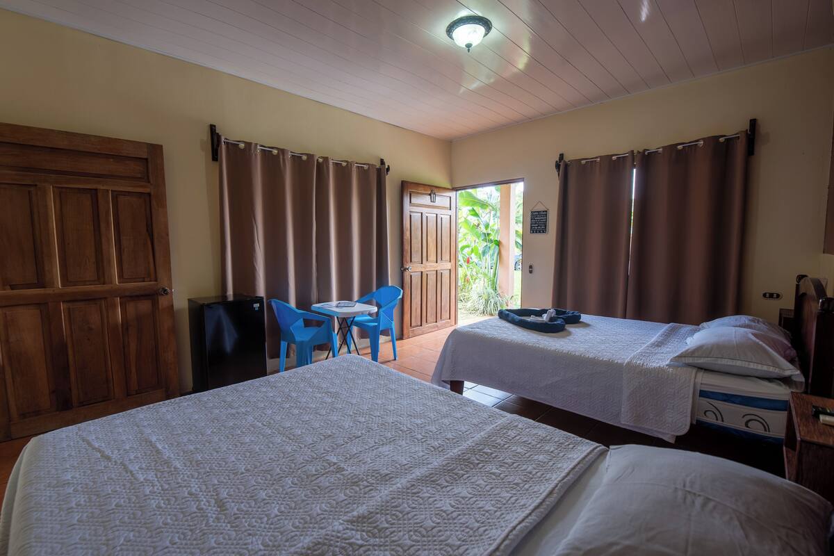 Une chambre avec deux lits, une petite table et des chaises.