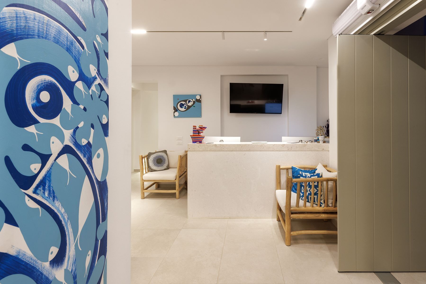 Una cocina moderna con televisor de pantalla plana, sillas de madera y una isla central.