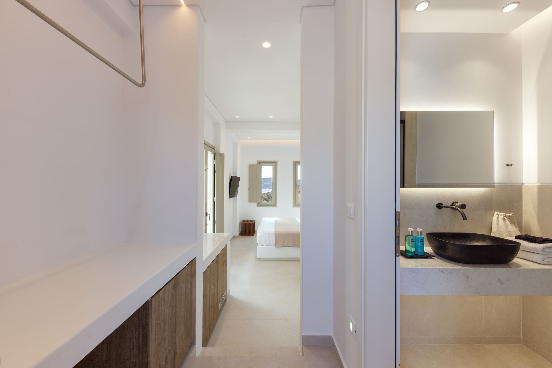 Un baño moderno con un lavamanos grande, un espejo y vista al mar.