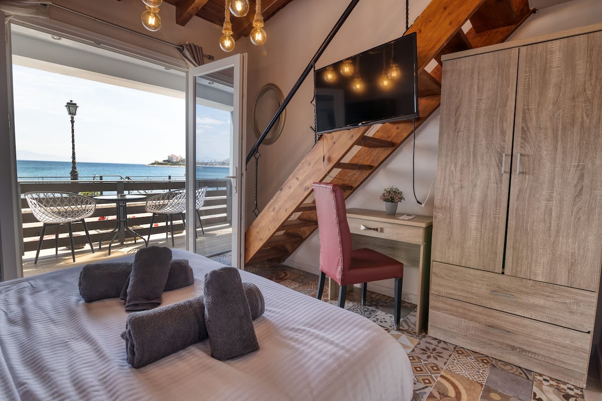 A bedroom with a bed, a desk, a chair, a TV, and a wardrobe.