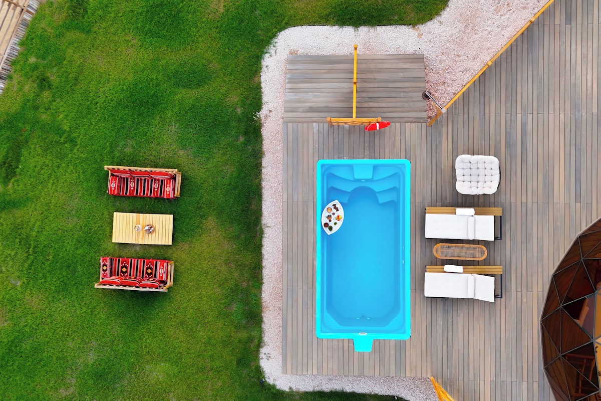 Ein Poolbereich auf dem Dach mit Whirlpool, Liegestühlen und einer Terrasse mit Gartenmöbeln.