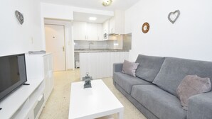 A modern living room with a grey sofa, a white coffee table, and a flat-screen TV. - MARISCAL 6 (1 BEDROOM) (Benidorm)
