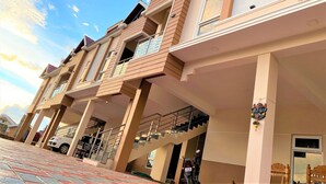 A multi-story residential building with balconies, a staircase, and a tiled ground floor. - AVALON STAYS  OOTY (Ootacamund)