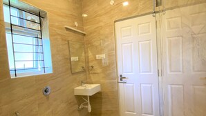 A modern bathroom with a toilet, sink, and shower. - AVALON STAYS  OOTY (Ootacamund)