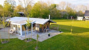 Ein modernes Haus mit Glaserker, Terrasse und Rasen.