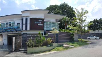 Set amidst lush greenery, this two-story building features a curved facade and a glass canopy entrance.
