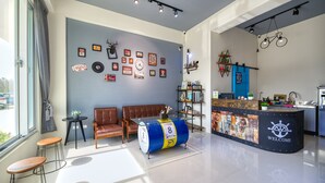 Uma área de recepção moderna com balcão azul, assentos de couro e diversas decorações nas paredes.