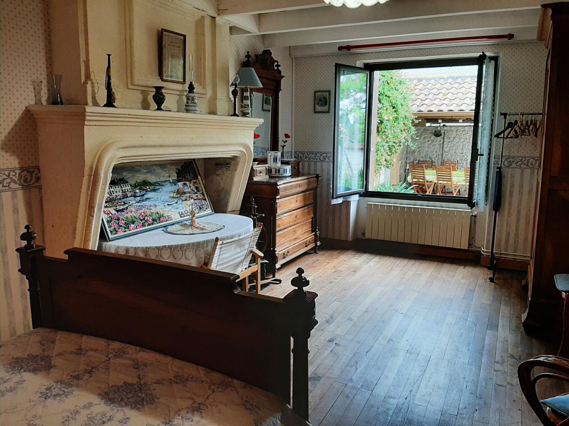 Um quarto com cama, lareira, janela com vista para o exterior e cômoda.