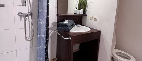 Een haardroger, handdoeken, zeep, toiletpapier