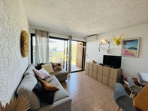 Relax in this stylish living room with a sofa, flat-screen TV, and dining area.