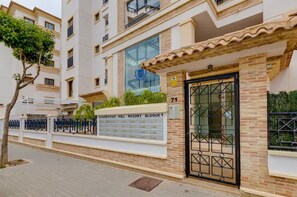 A gated entrance to a building with a sign indicating 'Guardamar Hill Resort Bungalow 1'.