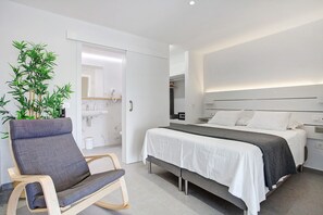 Une chambre à coucher moderne avec un lit, des tables de chevet, une chaise et une plante en pot.