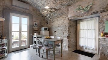 Una cucina rustica con pareti in pietra, un tavolo di legno e un lampadario.