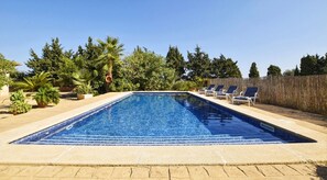 A rectangular swimming pool with a tiled edge, surrounded by lounge chairs and potted plants. - Holiday Home 'Ribas' with Mountain View, Wi-Fi and Air Conditioning (Santa Margarita)