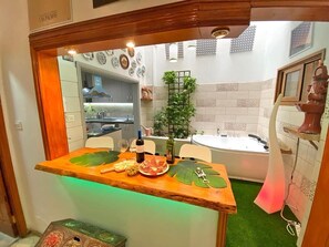 A kitchen with a wooden bar counter, a dining table, a sink, and a bathtub. - Vacation Home "La Luz" close to the Sea with Wi-Fi (Las Palmas de Gran Canaria)