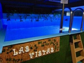 A pool area with a sign reading 'LAS VISIAS' and a wooden ladder.