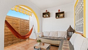 A cozy living area with a hammock, a sofa, a coffee table, and decorative shelves. - Holiday Home 'casa en la playa con piscina y terraza MAX' (Gran Alacant)