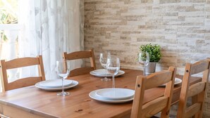 A dining table with chairs, plates, and wine glasses set for four. - Holiday Home 'Casa en la playa con piscinas 11 A' with Shared Pool, Wi-Fi and Air Conditioning (el Gran Alacant)