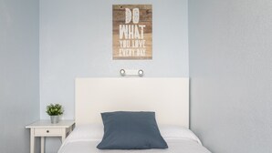 A bedroom with a bed, a bedside table with a plant, and a motivational wall art. - Holiday Home 'Casa en la playa con piscinas 11 A' with Shared Pool, Wi-Fi and Air Conditioning (el Gran Alacant)