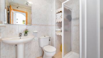 Ein Badezimmer mit Waschbecken, Toilette und Dusche.