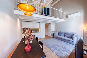 A modern living space with a dining area, kitchen, and a balcony.
