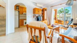Una cocina moderna con armarios de madera, un refrigerador y un comedor con mesa y sillas.