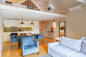 Een modern interieur met een eethoek, bank, trap en keuken.