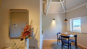 A modern room with a dining area, a mirror, and a vase with dried flowers. - Top Floor One Bedroom Apart for 3 nice Views (Oporto)