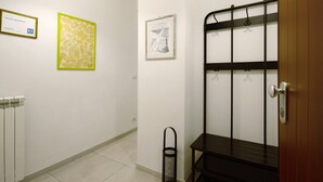 A hallway with a radiator, a framed picture, a metal rack, and a door. - Apartment "Sunrise" close to the Sea with Wi-Fi (Santa Margherita Ligure)