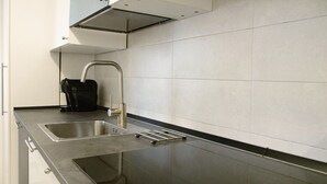 A modern kitchen with a stainless steel sink, a black coffee machine, and a sleek countertop. - Apartment "Sunrise" close to the Sea with Wi-Fi (Santa Margherita Ligure)