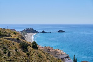 A coastal town with buildings along the beach, rocky outcrops, and clear blue sea. - Villa "Casa Beto" with Sea View, Pool, Garden & Wi-Fi (Almuñecar)