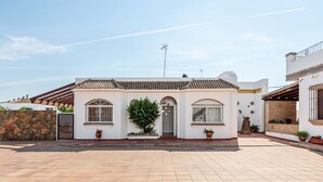 Une maison à deux étages, avec un toit en tuiles, un mur en pierre et une allée pavée.