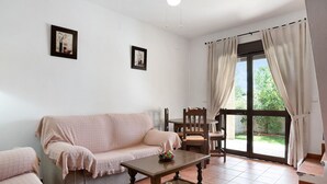 Ein Wohnzimmer mit einer Couch, einem Couchtisch und einem Essbereich mit Stühlen.