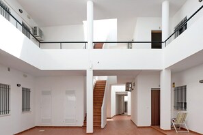 A spacious interior with a central staircase, white walls, and a tiled floor. - Apartment "Sagasta 1 - Andalmar" close to the Sea with Wi-Fi (Conil)